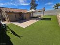 Large backyard featuring a concrete patio, artificial turf, and a gazebo at 7324 Saybrook Point Dr, Las Vegas, NV 89128