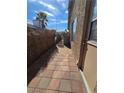 Sideyard with privacy lattice, tile paver walkway, and security gate at 7324 Saybrook Point Dr, Las Vegas, NV 89128