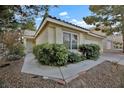 Well-maintained home with a tiled roof and landscaped front yard featuring mature green bushes at 7713 Shore Haven Dr, Las Vegas, NV 89128