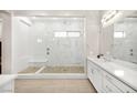 Elegant bathroom featuring a walk-in shower with pebble floor and a double sink vanity at 12119 Castilla Rain Ave, Las Vegas, NV 89138