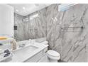 Modern bathroom featuring marble tile, floating vanity, and glass-enclosed shower at 2503 Cracked Stone St, Henderson, NV 89044