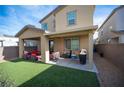 Inviting backyard featuring artificial grass and a covered patio with comfortable seating, ideal for outdoor entertaining at 3746 Bright Aquarius Ln, Henderson, NV 89052