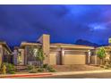 Home exterior features a two-car garage, desert landscaping, and a modern architectural style at 415 Point Sur Ave, Las Vegas, NV 89138