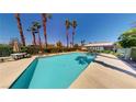Resort-style pool with crystal-clear water, palm trees, and ample lounging space at 5449 Bugle Way # 102, Las Vegas, NV 89108