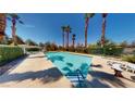 Beautiful community pool surrounded by lush landscaping and comfortable seating at 5449 Bugle Way # 102, Las Vegas, NV 89108
