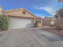 View of the facade with a circular window above the garage and xeriscaping in the front yard at 7089 Orange Grove Ln, Las Vegas, NV 89119