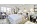 Stylishly decorated bedroom with a comfortable bed, elegant lighting, and a cozy reading chair at 730 S Royal Crest Cir # 424, Las Vegas, NV 89169