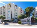 Condominium complex featuring a well-maintained sign, mature landscaping, and inviting architecture at 730 S Royal Crest Cir # 424, Las Vegas, NV 89169