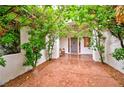 Charming entrance featuring a covered walkway with lush greenery, leading to a grey front door at 7565 N Torrey Pines Dr # A, Las Vegas, NV 89131