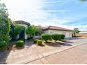 A well-maintained home featuring lush landscaping, a terracotta tile roof, and a spacious driveway at 7565 N Torrey Pines Dr # A, Las Vegas, NV 89131