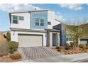 Contemporary home with an attached two-car garage, unique facade, and desert landscaping at 9690 Hiking Ave, Las Vegas, NV 89166