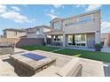 Outdoor living space features a fire pit, turf lawn, and a covered patio for relaxing and entertaining at 11548 Salt Creek Ave, Las Vegas, NV 89138