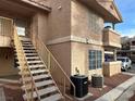 Two story condominium with stairs, neutral stucco, and well-maintained landscaping at 1830 N Pecos Rd # 230, Las Vegas, NV 89115