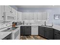 Modern kitchen with white upper cabinets, gray lower cabinets, quartz countertops, and stainless steel appliances at 262 Big Horn Dr, Boulder City, NV 89005