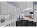 Well-lit kitchen featuring gray and white cabinets, quartz countertops, tiled backsplash and stainless steel appliances at 262 Big Horn Dr, Boulder City, NV 89005