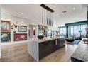 Open concept kitchen with waterfall island, modern lighting, and city views at 431 Tranquil Peak Ct, Henderson, NV 89012