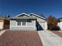 A well kept single story home with light gray exterior paint and reddish brown landscaping at 4661 Hutchinson Dr, Las Vegas, NV 89147