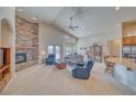 Bright living room featuring a stone fireplace, ceiling fan, and comfortable seating area at 5071 Andover Ct, Pahrump, NV 89061