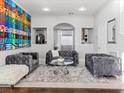 Living room with gray tufted sofas, tile floors, and an open concept layout at 5505 Big Sky Ln, Las Vegas, NV 89149