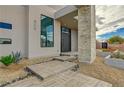 Stylish entryway featuring a modern door, stone accents, and desert-friendly plants at 5880 Westwind Rd, Las Vegas, NV 89118