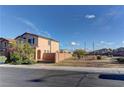 View of a well-kept house with a good-sized yard, situated on a neatly paved road, underneath a partly cloudy blue sky at 6307 Point Isabel Way, Las Vegas, NV 89122