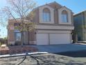 Charming two-story home featuring a large two car garage, classic windows, and desert landscaping at 8125 Rio De Janeiro Dr, Las Vegas, NV 89128