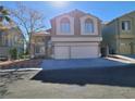 Charming two-story home featuring a large two car garage, classic windows, and desert landscaping at 8125 Rio De Janeiro Dr, Las Vegas, NV 89128