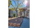 Inviting front yard with desert landscaping, mature tree, and classic architecture at 8125 Rio De Janeiro Dr, Las Vegas, NV 89128