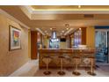Entertainment bar with four stools, pendant lighting and beautiful wooden cabinetry at 1 Hughes Center Dr # 308, Las Vegas, NV 89169