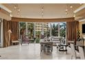 Bright living room with comfortable seating and large windows overlooking lush tropical landscaping at 1 Hughes Center Dr # 308, Las Vegas, NV 89169
