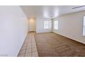 Bright living room with plush carpet, two windows, and tiled entryway at 11036 Parete Ct, Las Vegas, NV 89141