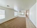 Spacious living room with carpeted floors, neutral walls, ceiling fan, and natural light at 11036 Parete Ct, Las Vegas, NV 89141