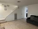 Open living space with tiled floors, neutral walls, access to stairs and under-stairs storage at 2692 Matogroso Ln, Las Vegas, NV 89121