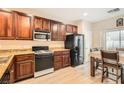 Traditional-style kitchen featuring brown wooden cabinetry, granite countertops, and modern appliances at 3411 Holly Ave, Las Vegas, NV 89106