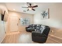 Well-lit living room features light hardwood floors, modern fan, and a comfortable, reclining leather sofa at 3411 Holly Ave, Las Vegas, NV 89106
