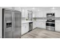 Bright kitchen features stainless steel appliances, modern fixtures, and white cabinetry at 3449 Lorilou Ln # 2, Las Vegas, NV 89121