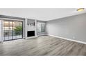 Bright living room features gray laminate floors, sliding glass doors, and a decorative brick fireplace at 3449 Lorilou Ln # 2, Las Vegas, NV 89121