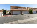 Exterior view of home featuring multiple garages with brick accents and mature trees, creating curb appeal at 3484 Nightflower Ln # B, Las Vegas, NV 89121