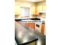 Kitchen featuring wood cabinets, black countertops, and white appliances at 4042 Morning Peace St, Las Vegas, NV 89115