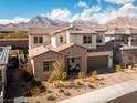 Aerial view of the beautiful home featuring a two-car garage, brick driveway, and lush desert landscaping at 421 Malpaso St, Las Vegas, NV 89138