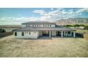 Rear view of newly constructed home with covered patio space overlooking expansive backyard at 6383 Horse Dr, Las Vegas, NV 89131