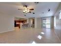 Open-concept living room and kitchen featuring tile flooring, ceiling fan, and access to the backyard at 6816 Royal Poinciana Ct, Las Vegas, NV 89131