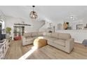 Spacious and bright living room with hardwood floors, recessed lighting, a comfortable sofa, and a decorative chandelier at 9339 Square Dance Pl # 103, Las Vegas, NV 89178