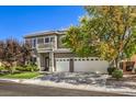 Charming two-story home featuring a balcony, manicured lawn, and a three-car garage at 10662 Bonchester Hill St, Las Vegas, NV 89141