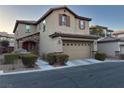 Inviting two-story home featuring a two-car garage, landscaped yard, and classic architectural details at 10941 Prudhoe Bay St, Las Vegas, NV 89179