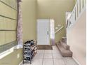 Clean entryway featuring tile flooring, white front door, staircase, and neutral wall color at 2526 Begonia Valley Ave, Henderson, NV 89074