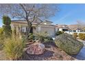 Well-landscaped front yard featuring desert landscaping, a rock feature, and a two-car garage at 3805 Sorrowing Sparrow Ct, North Las Vegas, NV 89032