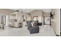 Open-concept living room with tile floors, high ceilings, and a view of the kitchen at 5049 Forest Oaks Dr, Las Vegas, NV 89149