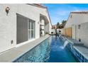 Backyard pool with waterfall features and a patio area for outdoor entertaining at 5049 Forest Oaks Dr, Las Vegas, NV 89149