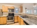 Bright kitchen featuring wood cabinetry, stainless steel appliances, and granite countertops at 5055 W Hacienda Ave # 1116, Las Vegas, NV 89118